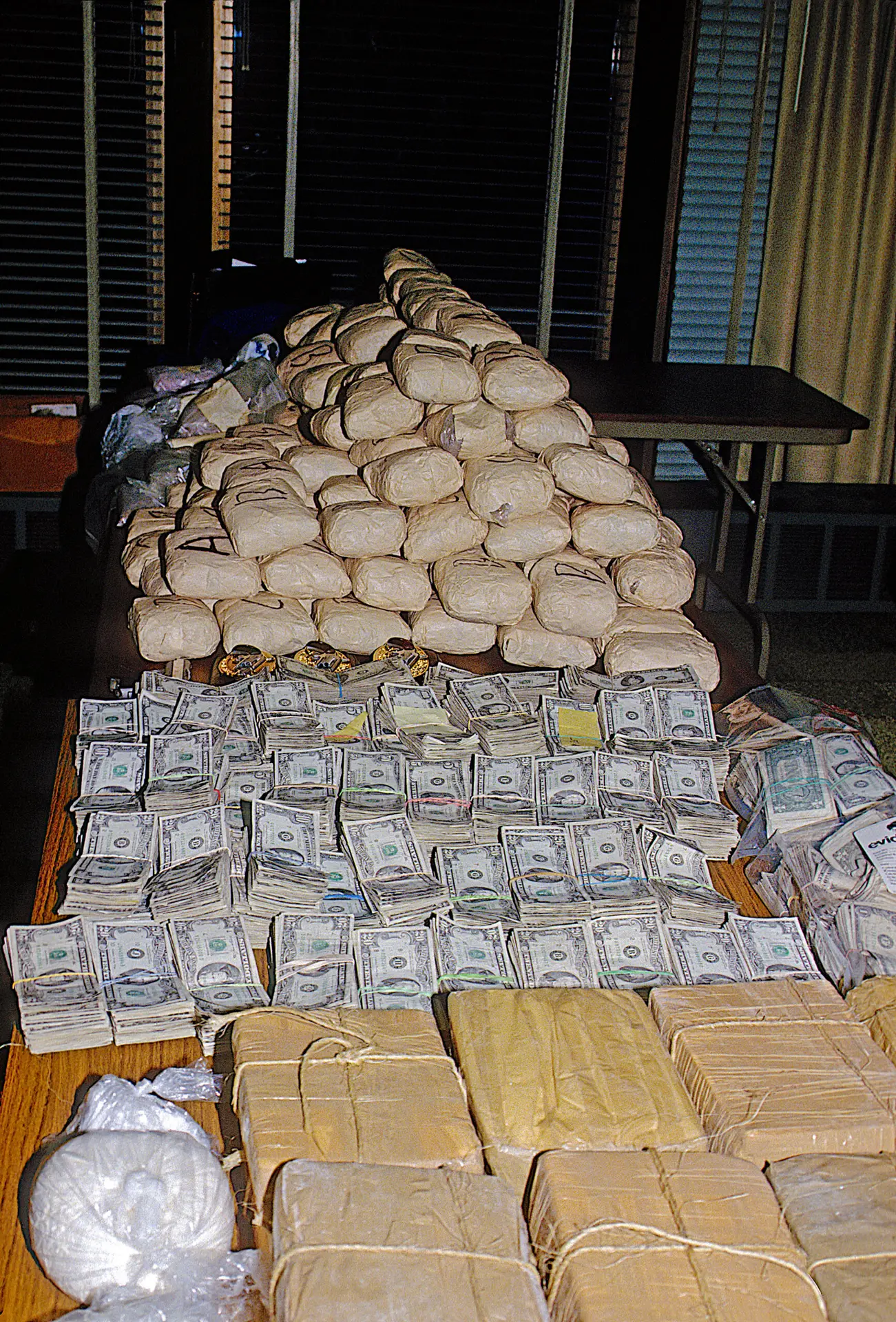 A table topped with stacks of money and bags.