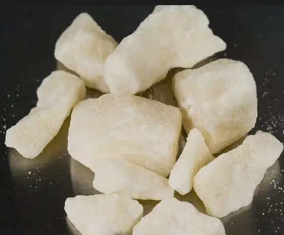 A pile of white food on top of a black surface.